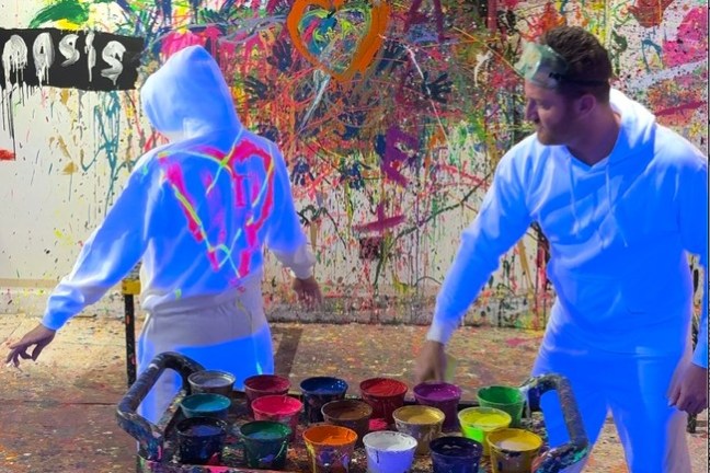 a man and a woman standing next to a graffiti covered wall